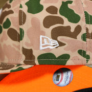 The New Era logo on the New York Yankees Duck Camo Neon Orange Undervisor World Series Side Patch Fitted Cap | Camo Tan 59Fifty Cap