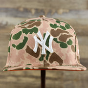 The front of the New York Yankees Duck Camo Neon Orange Undervisor World Series Side Patch Fitted Cap | Camo Tan 59Fifty Cap