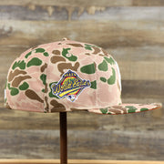 The wearer's left of the New York Yankees Duck Camo Neon Orange Undervisor World Series Side Patch Fitted Cap | Camo Tan 59Fifty Cap