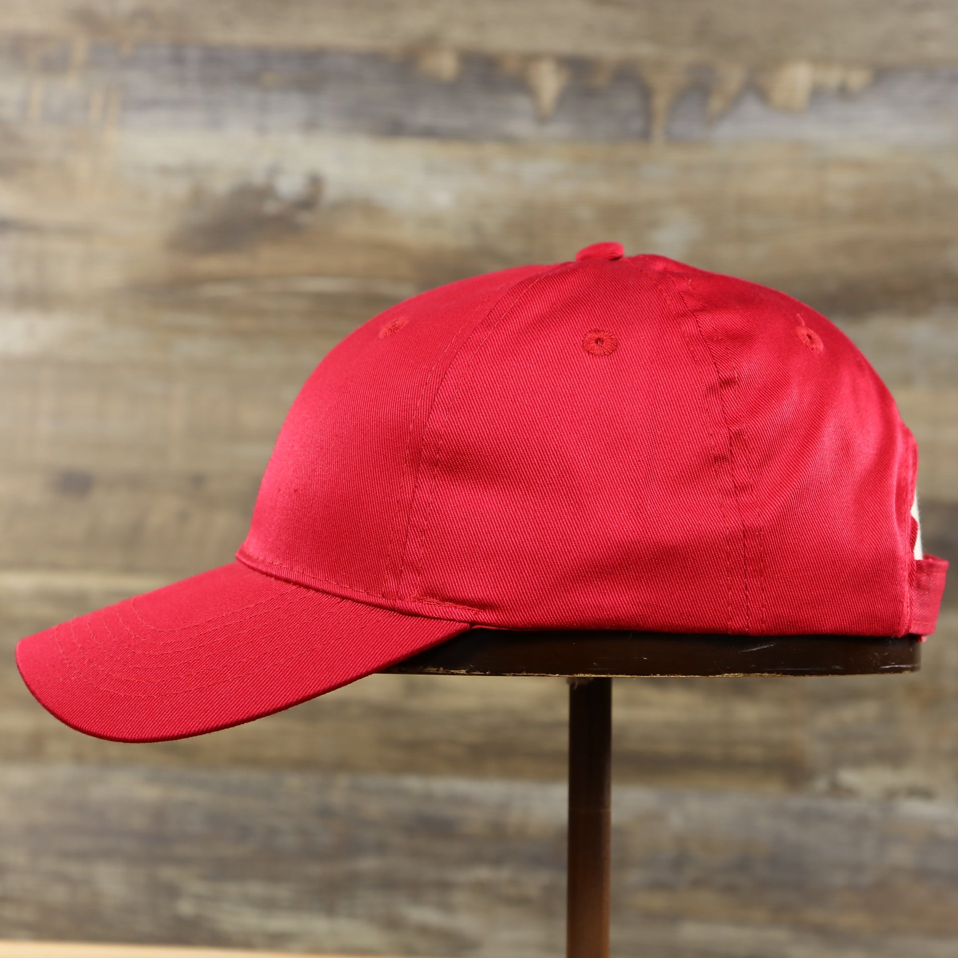 The wearer's left of the Youth Cardinal Red Flat Brim Blank Baseball Hat | Kid’s Red Dad Hat