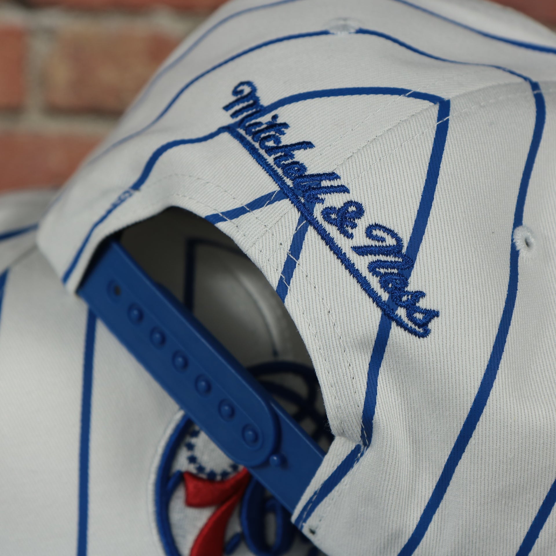 mitchell and ness logo on the Philadelphia 76ers Vintage Pinstripe Baseball Hat | Retro Mitchell and Ness White Pinstripe Snapback Hat