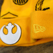 The New Era Logo on the C3PO Rebel Alliance Cuffed Logo Winter Beanie With Pom Pom | Yellow Winter Beanie
