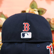 The Mini Red Sox Logo and MLB Batterman Logo on the Boston Red Sox Pink Undervisor Sakura Tree Embroidered 59Fifty Fitted Cap | Navy Blue 59Fifty Cap