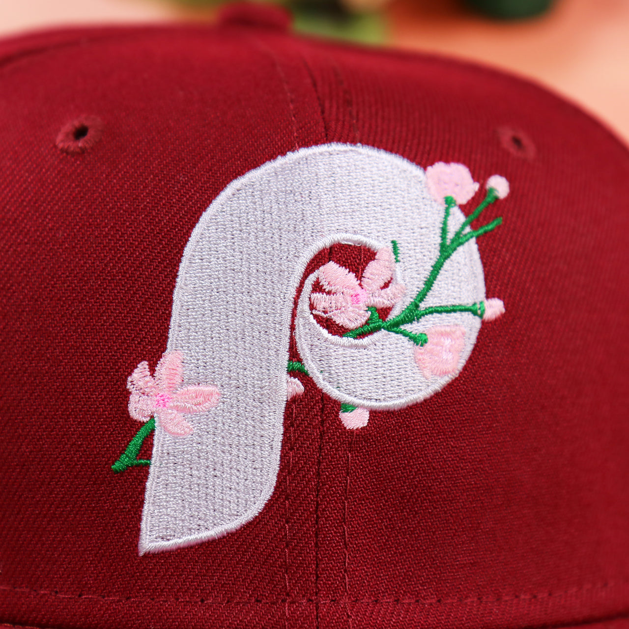 The Cooperstown Phillies Sakura Logo on the Cooperstown Philadelphia Philadelphia Pink Undervisor Sakura Tree Embroidered 59Fifty Fitted Cap | Maroon 59Fifty Cap