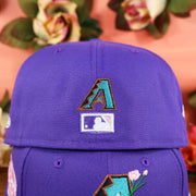 The Mini Diamondbacks logo and Retro MLB Batterman logo on the Cooperstown Arizona Diamondbacks Pink Undervisor Sakura Tree Embroidered 59Fifty Fitted Cap | Purple 59Fifty Cap