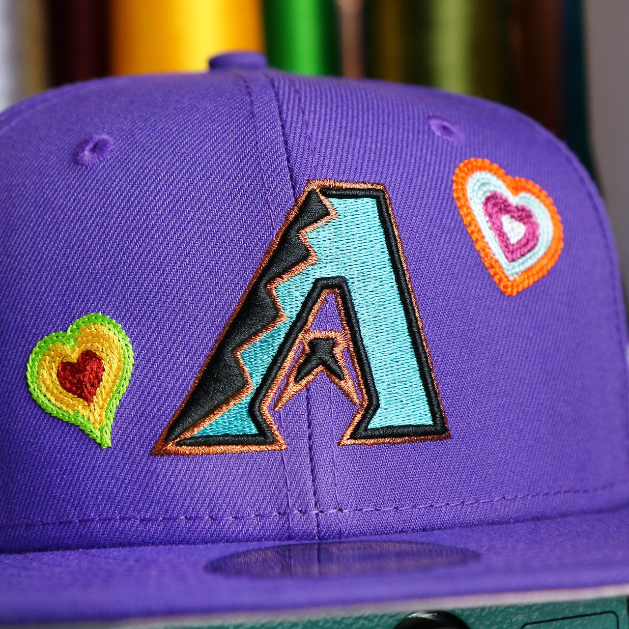 The Cooperstown Diamondbacks Logo on the Cooperstown Arizona Diamondbacks All Over Embroidered Chain Stitch Heart Pink Bottom 59Fifty Fitted Cap | Purple 59Fifty Cap