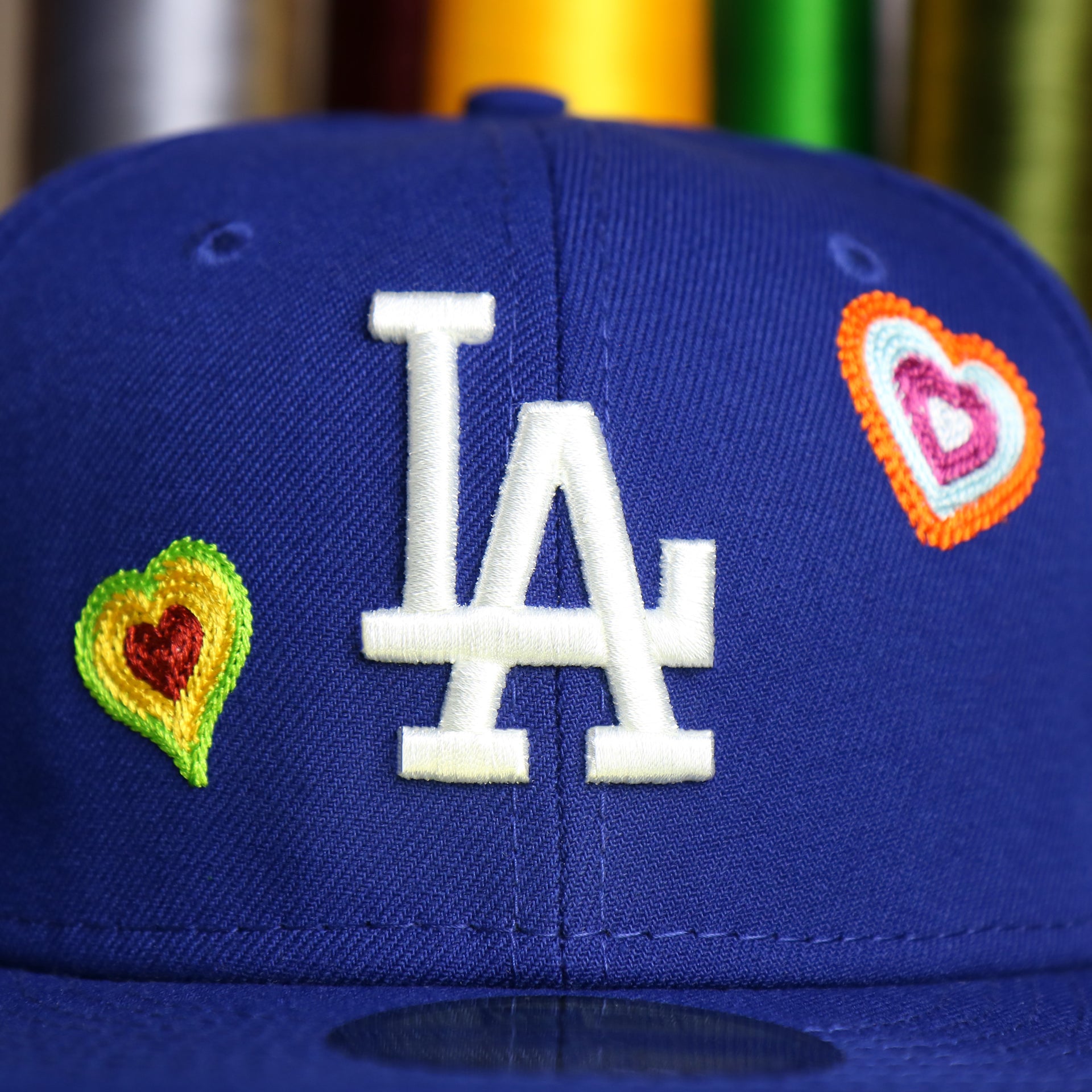 The Dodgers Logo on the Los Angeles Dodgers All Over Embroidered Chain Stitch Heart Pink Bottom 59Fifty Fitted Cap | Royal Blue 59Fifty Cap