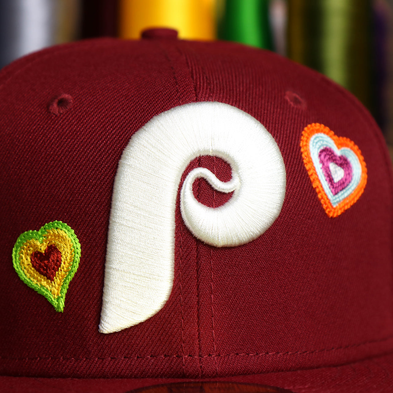 The Cooperstown Phillies Logo on the Cooperstown Philadelphia Phillies All Over Embroidered Chain Stitch Heart Pink Bottom 59Fifty Fitted Cap | Maroon 59Fifty Cap
