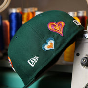 The New Era Logo on the Oakland Athletics All Over Embroidered Chain Stitch Heart Pink Bottom 59Fifty Fitted Cap | Green 59Fifty Cap