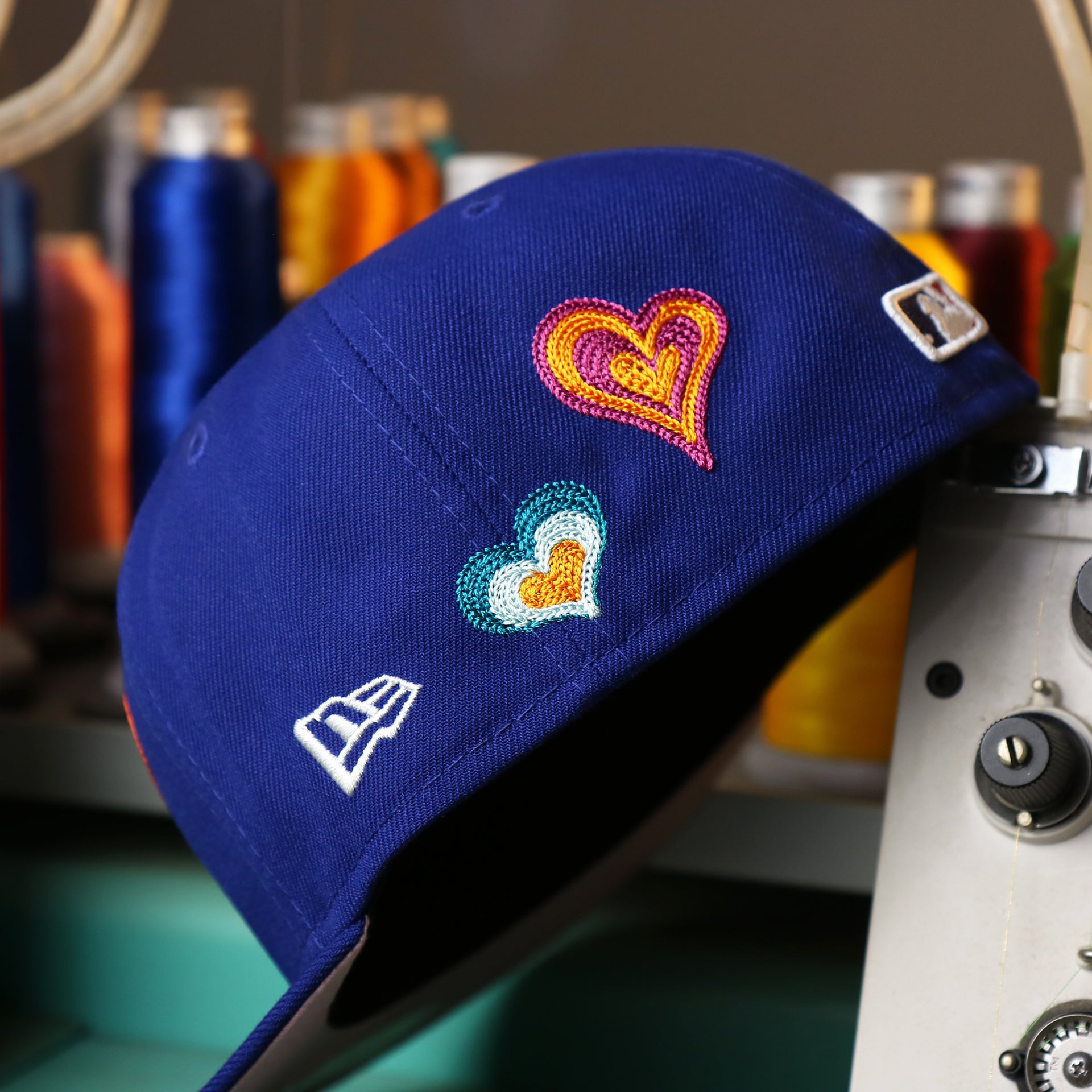The New Era Logo on the Los Angeles Dodgers All Over Embroidered Chain Stitch Heart Pink Bottom 59Fifty Fitted Cap | Royal Blue 59Fifty Cap