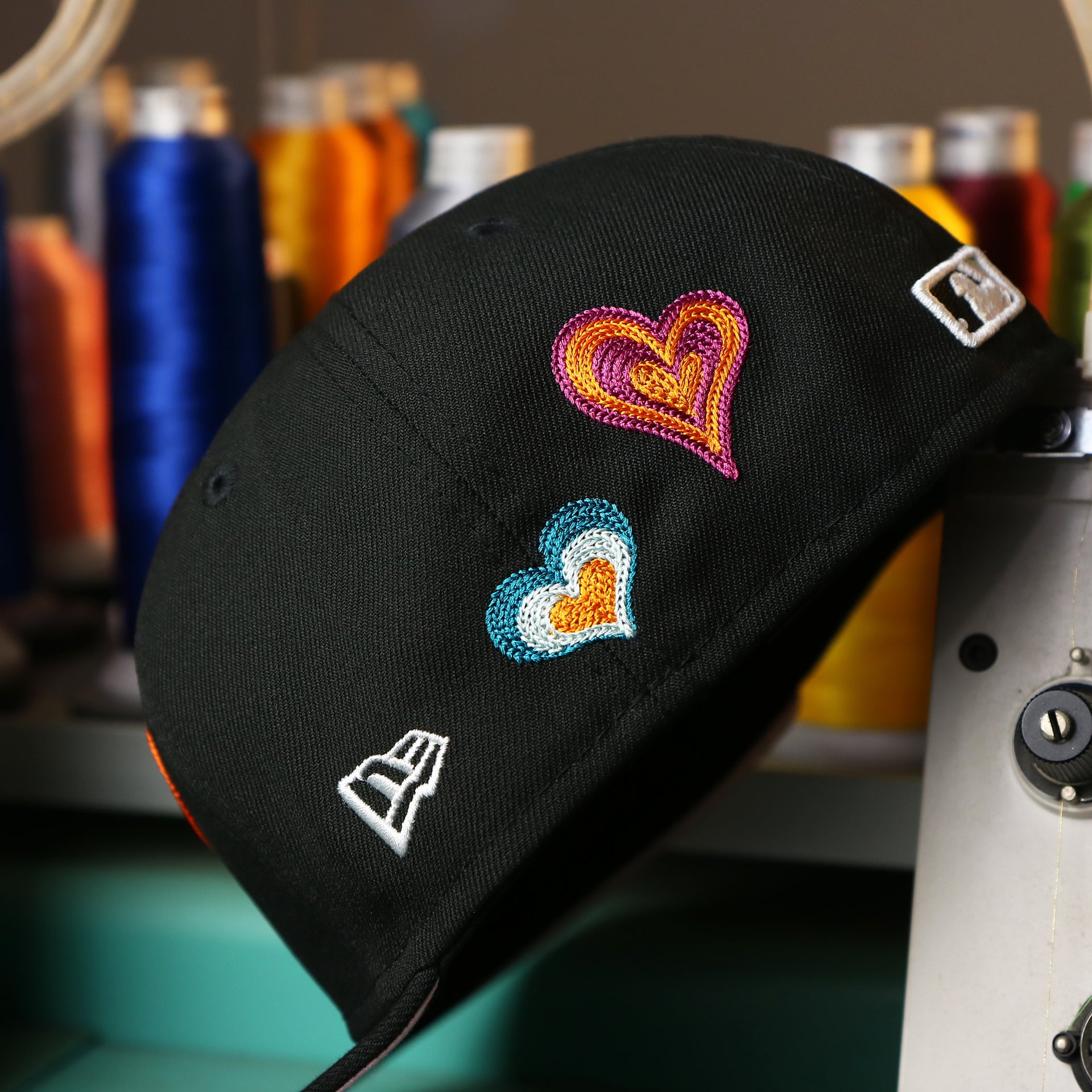 The New Era Logo on the Pittsburgh Pirates All Over Embroidered Chain Stitch Heart Pink Bottom 59Fifty Fitted Cap | Black 59Fifty Cap