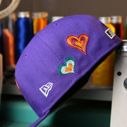 The New Era Logo on the Cooperstown Arizona Diamondbacks All Over Embroidered Chain Stitch Heart Pink Bottom 59Fifty Fitted Cap | Purple 59Fifty Cap