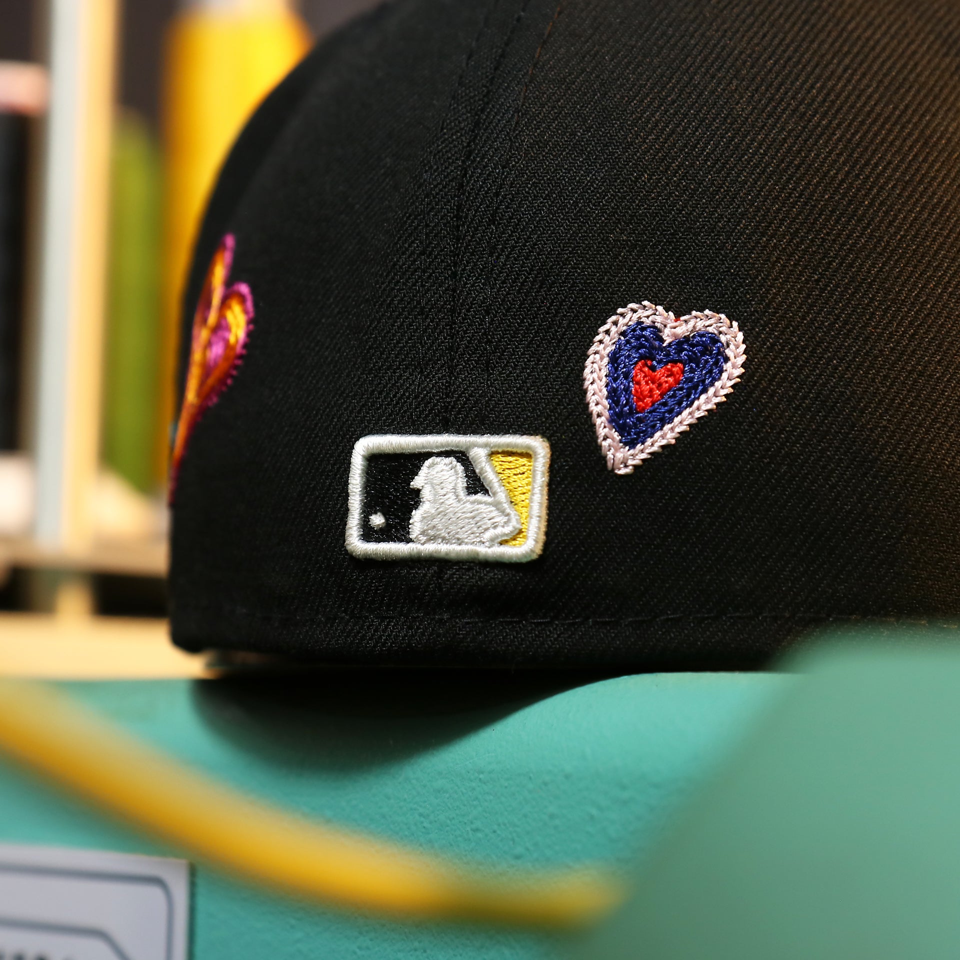 The MLB Batterman Logo on the Pittsburgh Pirates All Over Embroidered Chain Stitch Heart Pink Bottom 59Fifty Fitted Cap | Black 59Fifty Cap