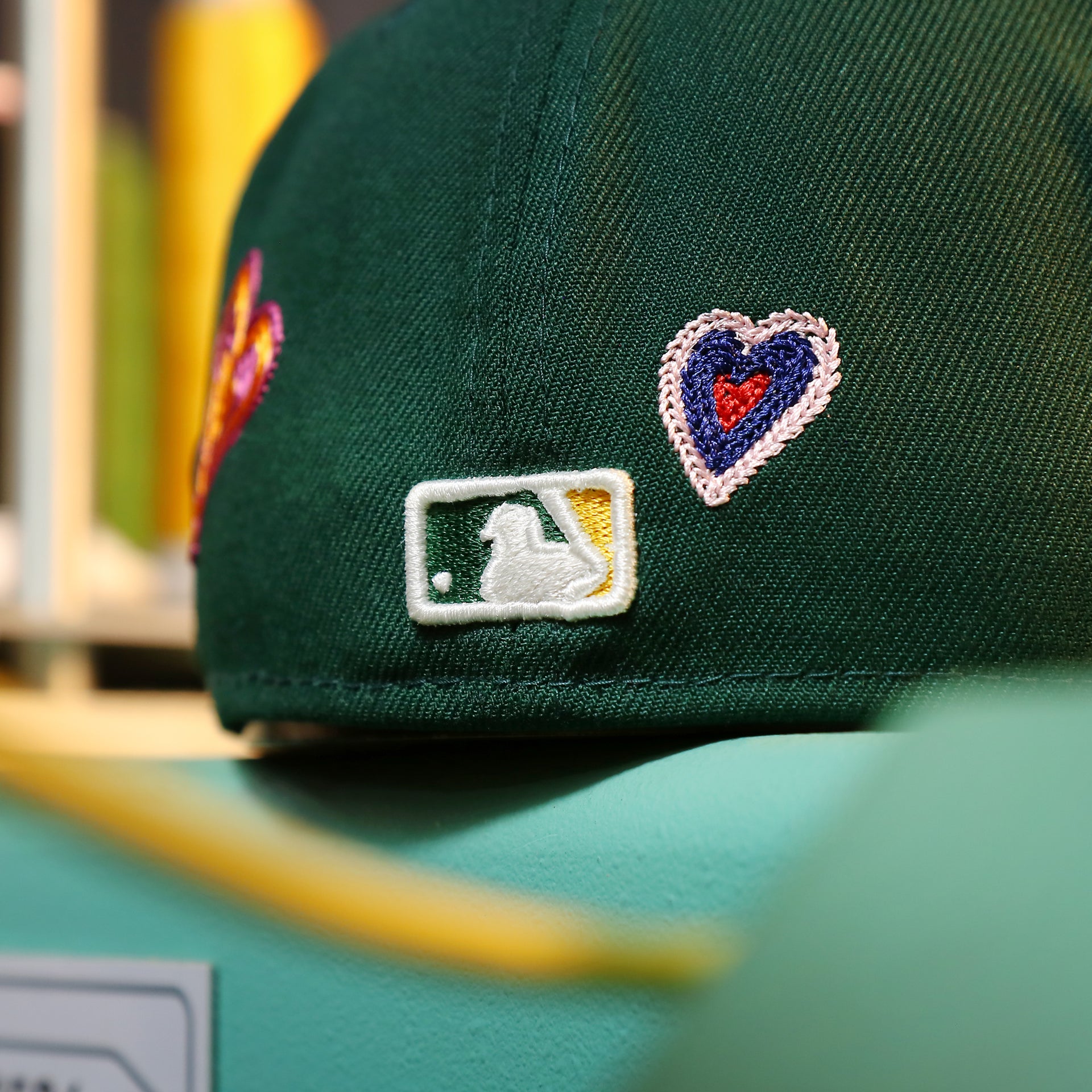 The MLB Batterman Logo on the Oakland Athletics All Over Embroidered Chain Stitch Heart Pink Bottom 59Fifty Fitted Cap | Green 59Fifty Cap
