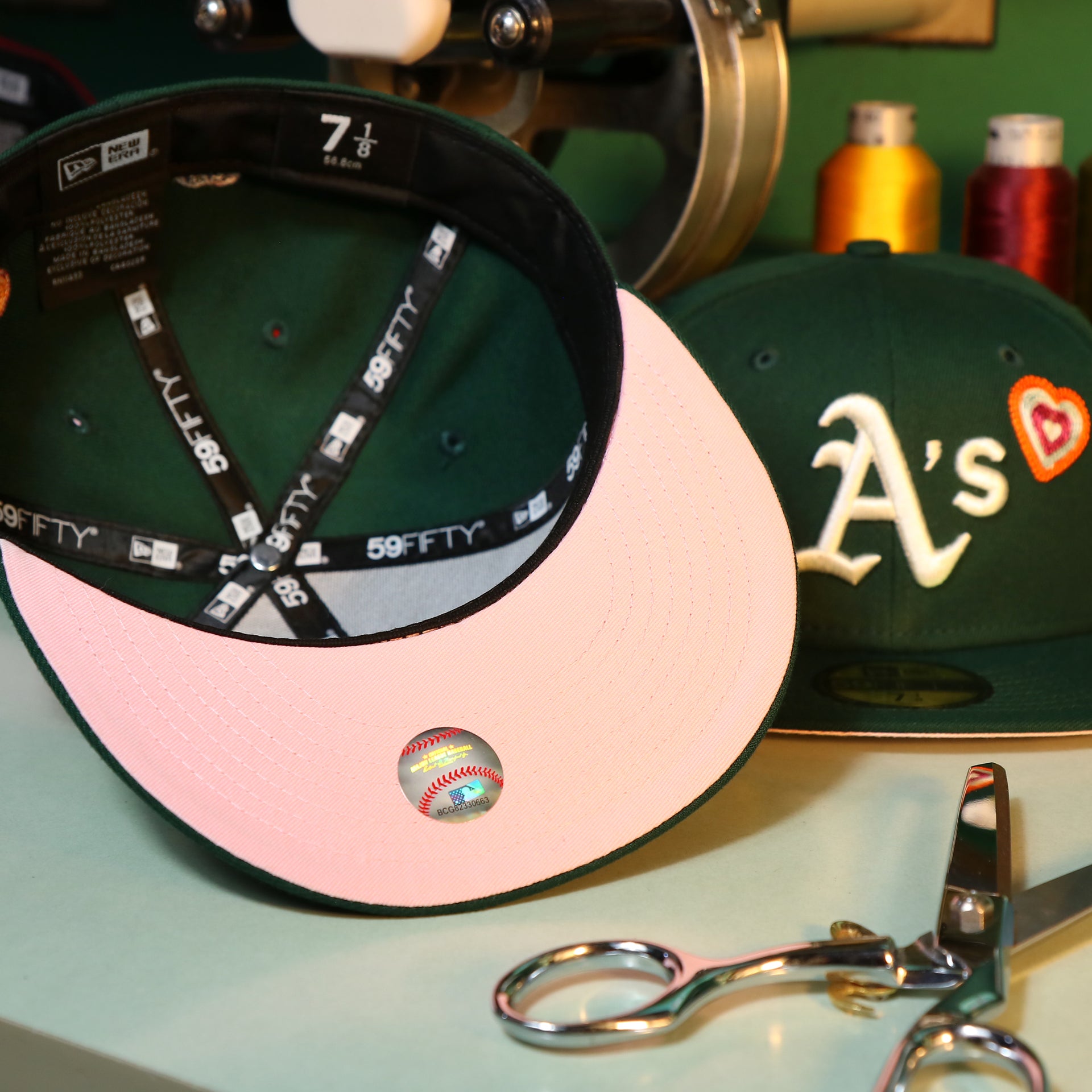 The Pink Undervisor on the Oakland Athletics All Over Embroidered Chain Stitch Heart Pink Bottom 59Fifty Fitted Cap | Green 59Fifty Cap