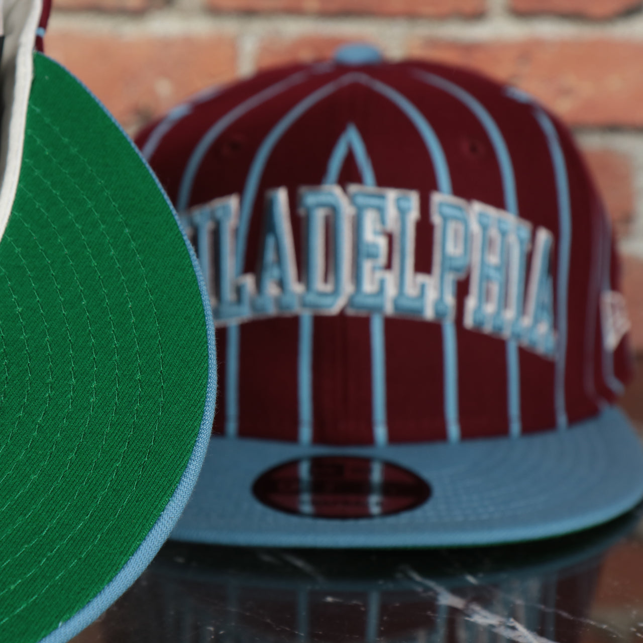 green under visor on the Cooperstown Philadelphia Phillies City Arch Striped 9Fifty Snapback Cap | Maroon 9Fifty Cap