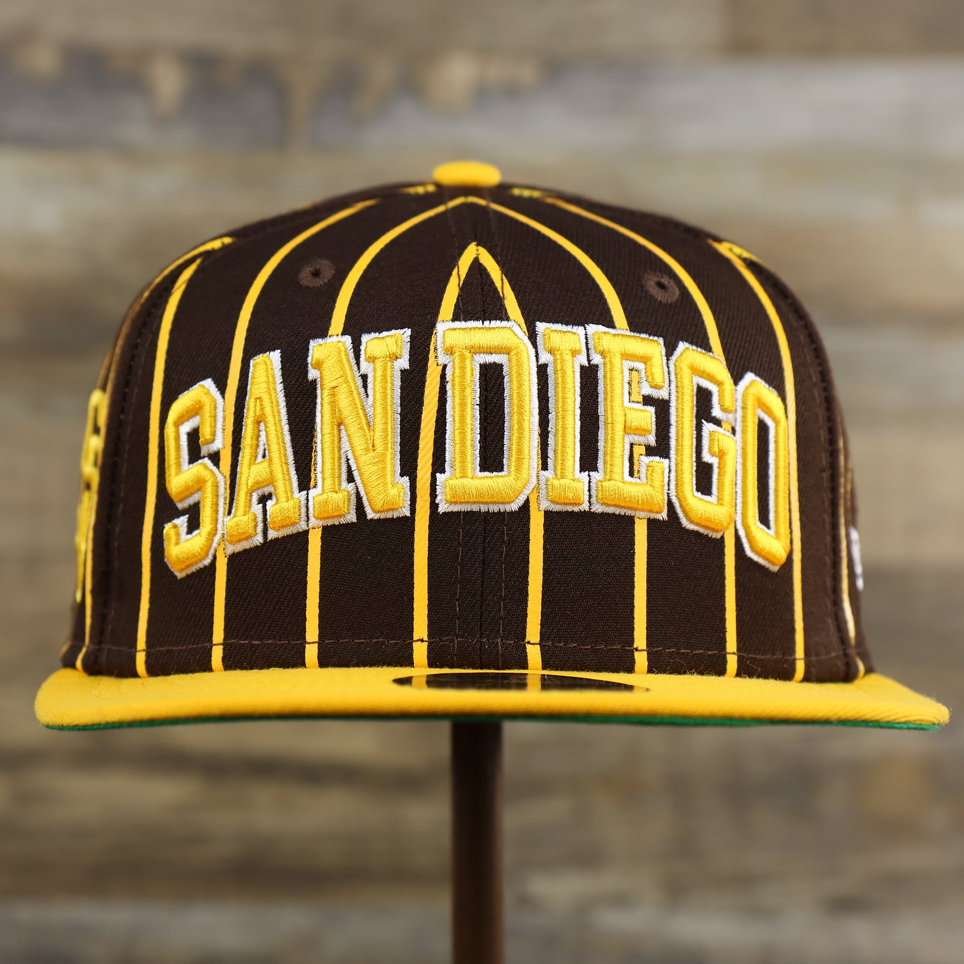 The front of the San Diego Padres City Arch Pinstriped 9Fifty Snapback Cap | Brown 9Fifty Cap
