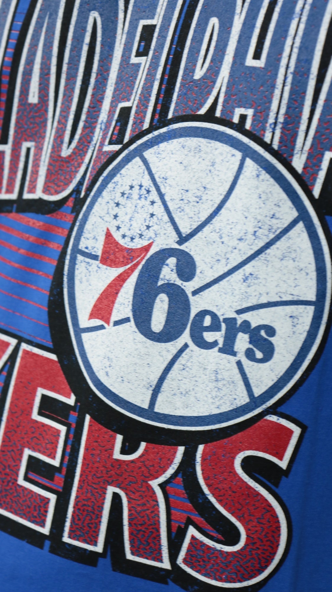 76ers logo on the Philadelphia 76ers NBA Hardwood Classics Incline Stacked Tee | Royal Blue T-shirt