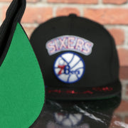 green under visor on the Philadelphia 76ers NBA Front Loaded "Phila" script Green bottom Black Snapback Hat | Mitchell and Ness Snapback Cap