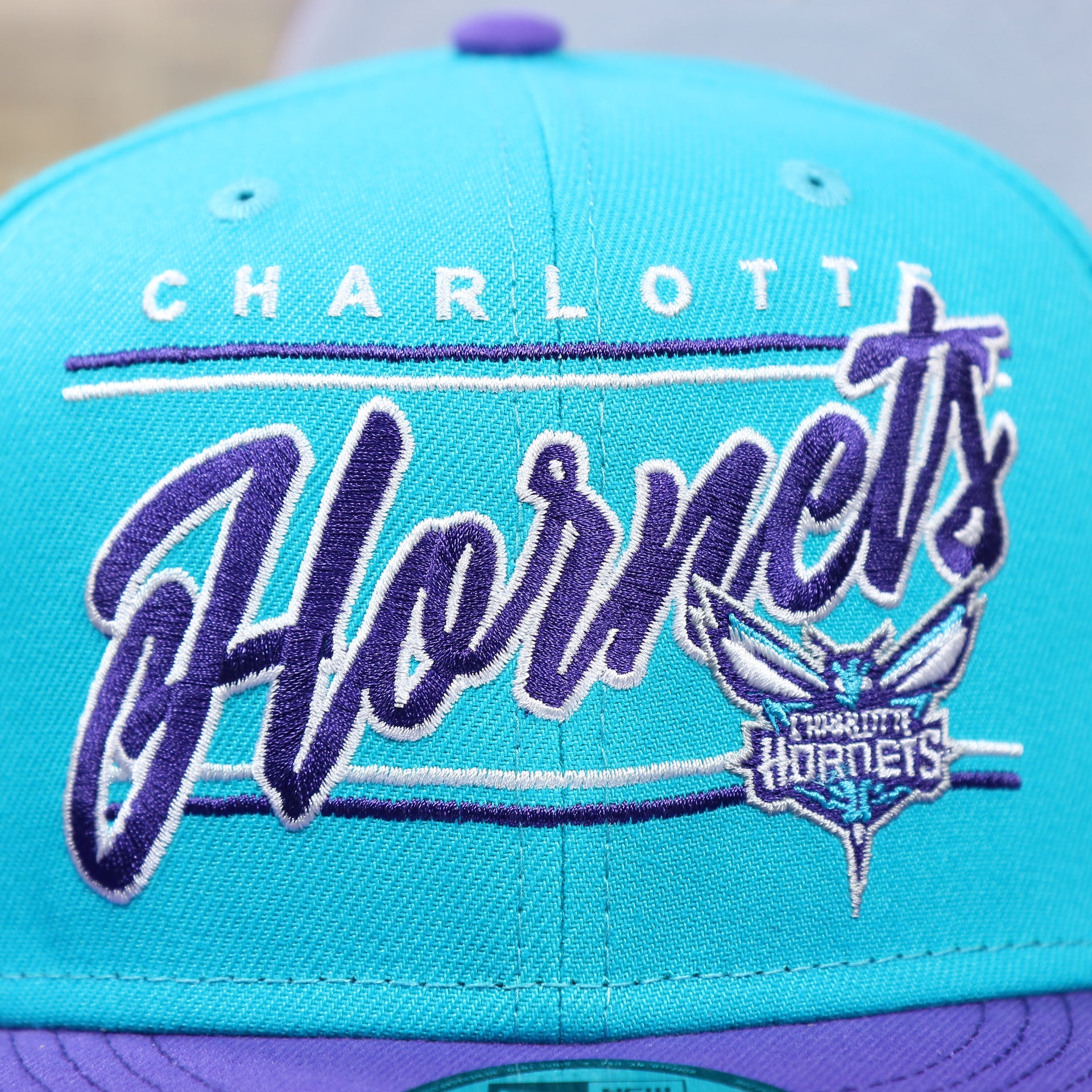 The Charlotte Hornets Team Script on the Charlotte Hornets Team Script Gray Bottom 9Fifty Snapback | Turquoise and Purple Snap Cap