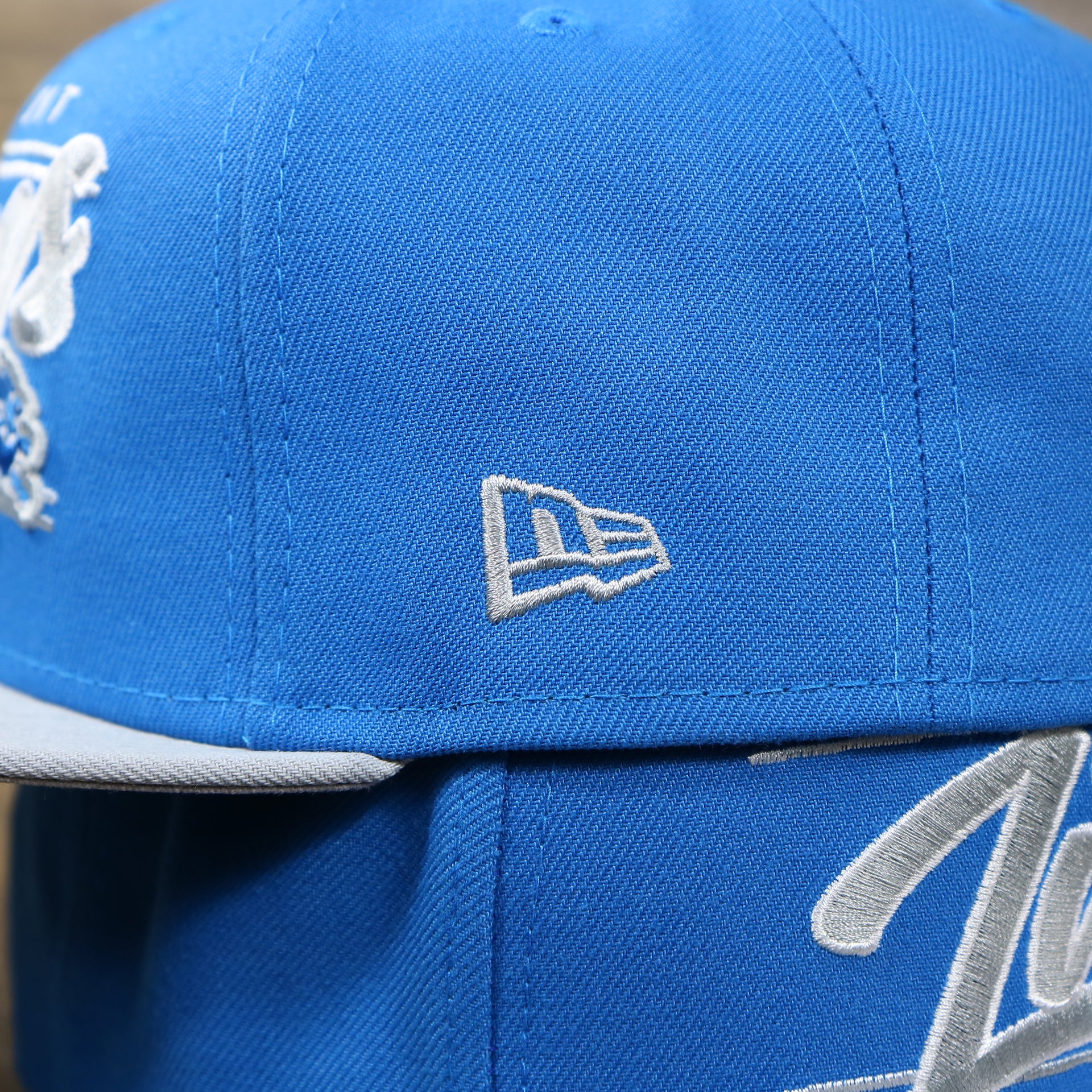 The New Era logo on the Detroit Lions Team Script Gray Bottom 9Fifty Snapback | Blue and Gray Snap Cap