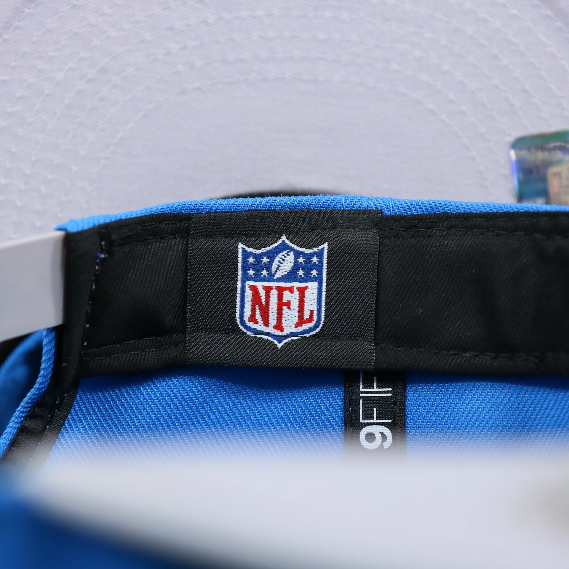 The NFL tag on the Detroit Lions Team Script Gray Bottom 9Fifty Snapback | Blue and Gray Snap Cap