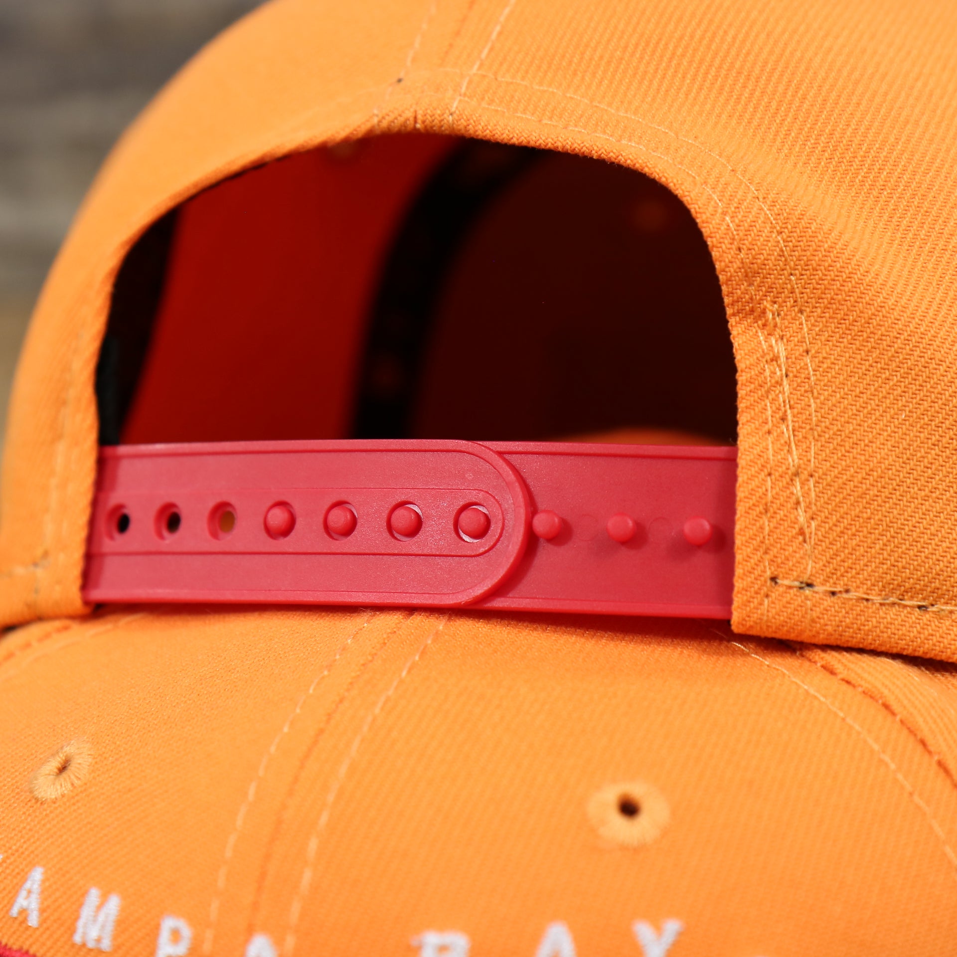 The Red Adjustable Strap on the Tampa Bay Buccaneers Team Script Gray Bottom 9Fifty Snapback | Orange And Red Snap Cap