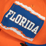 florida jumbotron side patch on the Florida Gators NCAA Jumbotron "Florida" Ripped Wordmark side patch Grey Bottom Yellow/Navy Snapback hat | Mitchell and Ness Two Tone Snap Cap