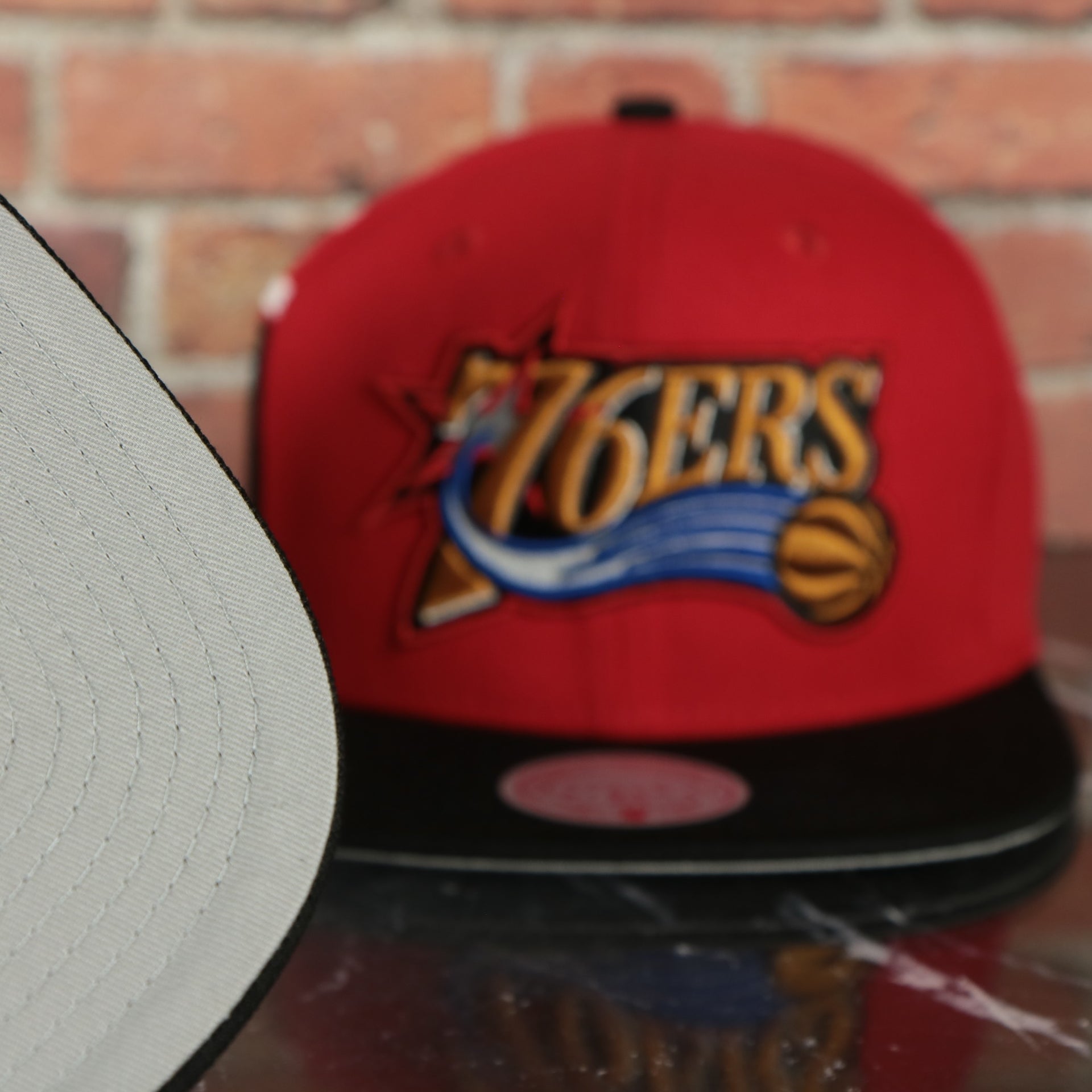 grey under visor on the Philadelphia 76ers Hardwood Classics Jumbotron "76ers" Ripped Wordmark side patch Grey Bottom Red/Black Snapback hat | Mitchell and Ness Two Tone Snap Cap