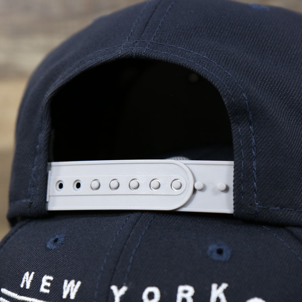 The gray adjustable strap on the New York Yankees "Team Script" College Bar Style 9Fifty Snapback Hat | Current Logo, Navy/Grey
