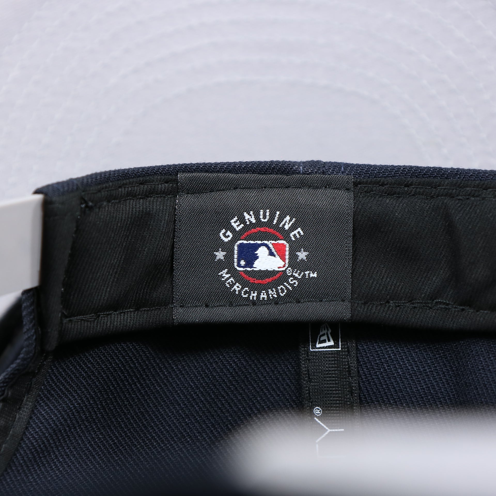 The Genuine Merchandise Tag on the New York Yankees "Team Script" College Bar Style 9Fifty Snapback Hat | Current Logo, Navy/Grey