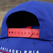 The Red adjustable strap on the Philadelphia 76ers Team Script Gray Bottom 9Fifty Snapback | Royal Blue And Red Snap Cap