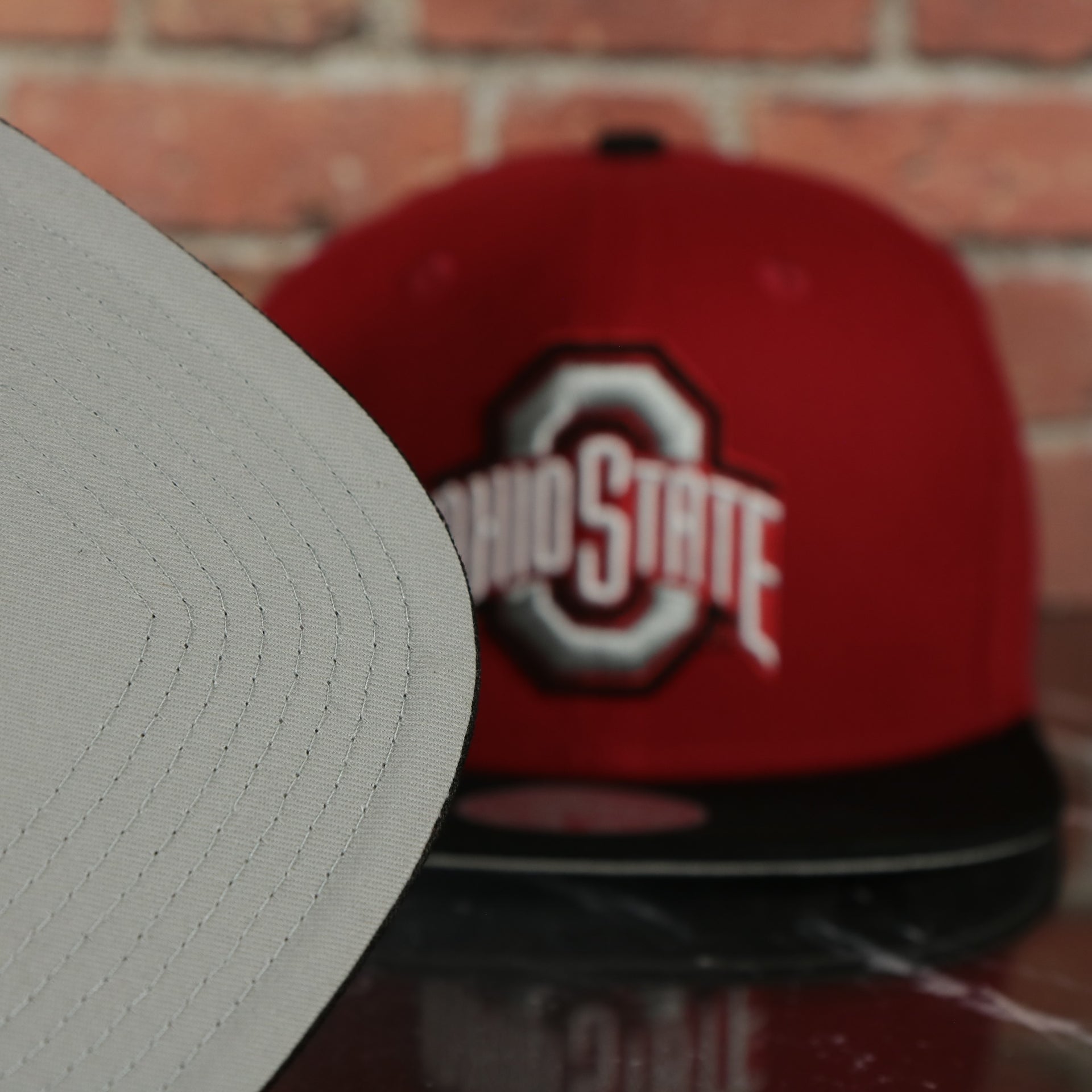 grey under visor on the Ohio State Buckeyes NCAA Jumbotron "Ohio State" Ripped Wordmark side patch Grey Bottom Red/Black Snapback hat | Mitchell and Ness Two Tone Snap Cap