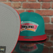 grey under visor on the San Antonio Spurs Hardwood Classics Jumbotron Spurs Ripped Logo side patch Grey Bottom Teal/Red Snapback hat | Mitchell and Ness Two Tone Snap Cap