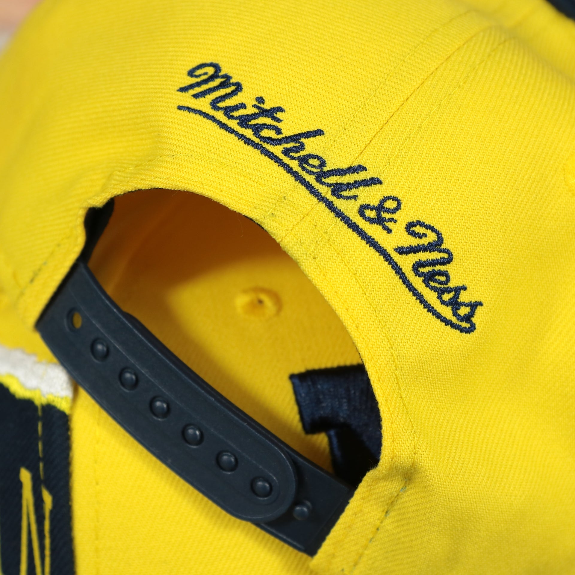 mitchell and ness logo on the Michigan Wolverines NCAA Jumbotron "Michigan" Ripped Wordmark side patch Grey Bottom Yellow/Navy Snapback hat | Mitchell and Ness Two Tone Snap Cap