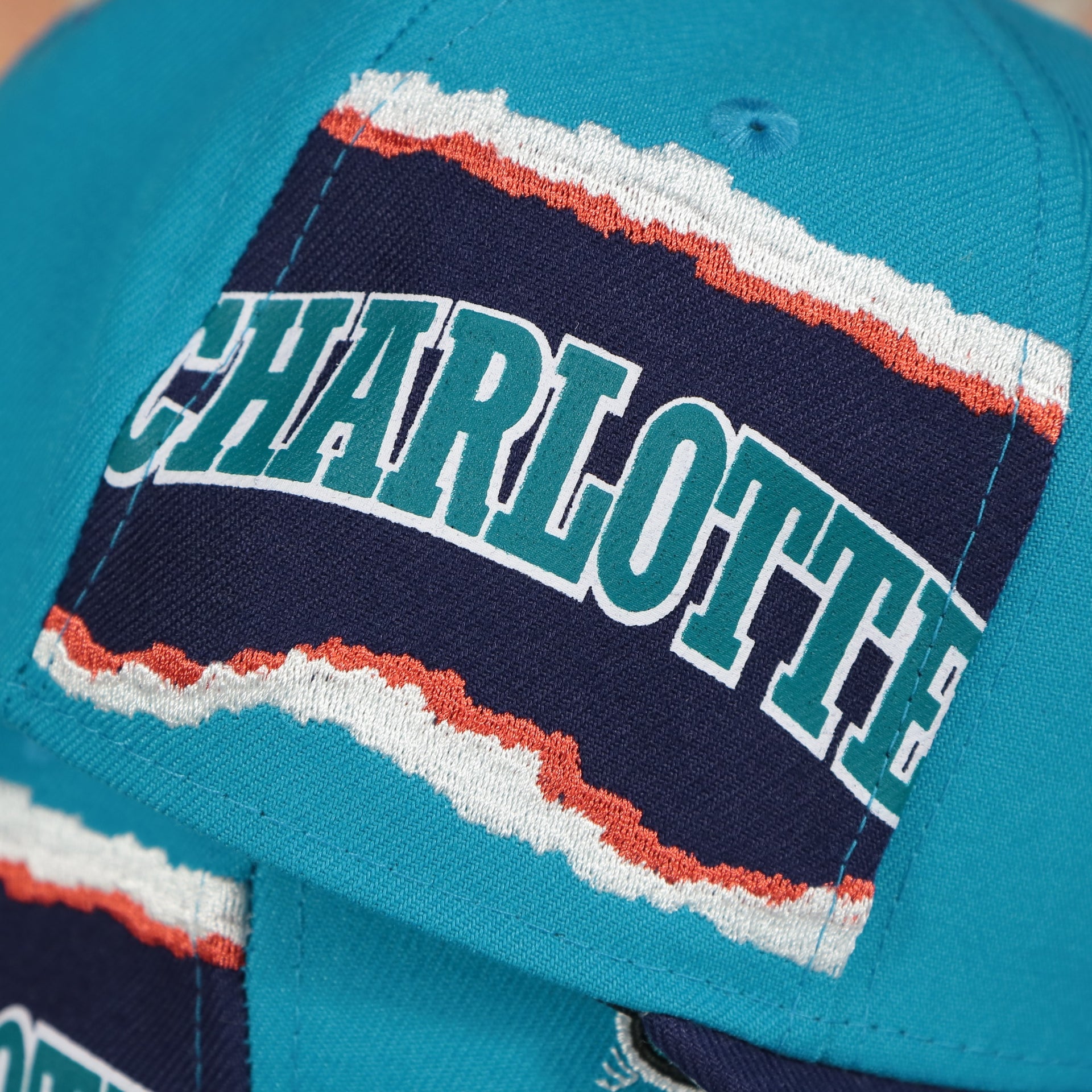 charlotte ripped wordmark on the Charlotte Hornets Hardwood Classics Jumbotron "Charlotte" Ripped Wordmark side patch Grey Bottom Teal/Purple Snapback hat | Mitchell and Ness Two Tone Snap Cap