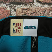 HWC label on the Charlotte Hornets Hardwood Classics Jumbotron "Charlotte" Ripped Wordmark side patch Grey Bottom Teal/Purple Snapback hat | Mitchell and Ness Two Tone Snap Cap