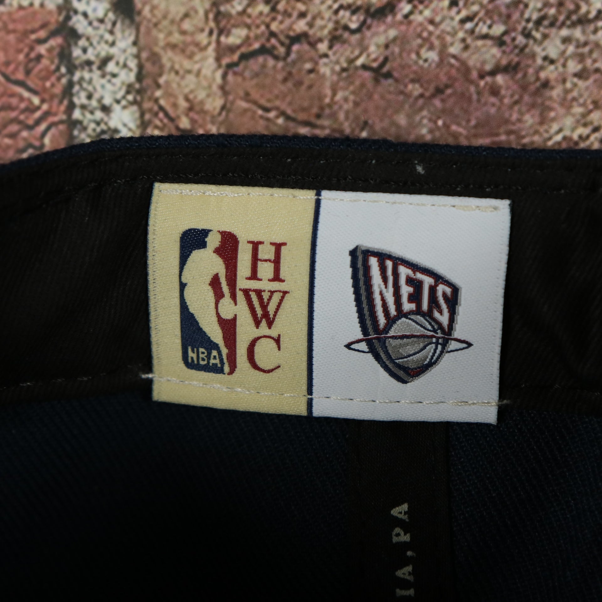 HWC label on the New Jersey Nets Hardwood Classics Jumbotron "Nets" Ripped Wordmark side patch Grey Bottom Navy/Red Snapback hat | Mitchell and Ness Two Tone Snap Cap