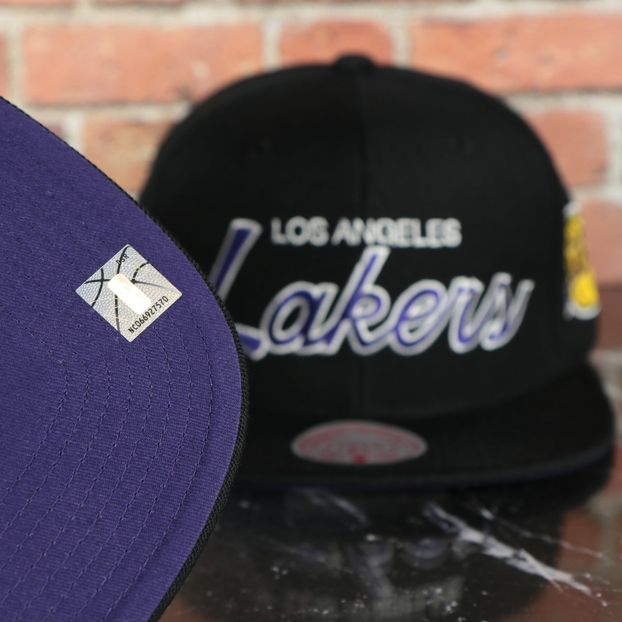 purple under visor on the Los Angeles Lakers Vintage Retro NBA Team Script 2.0 Mitchell and Ness Snapback Hat | Black