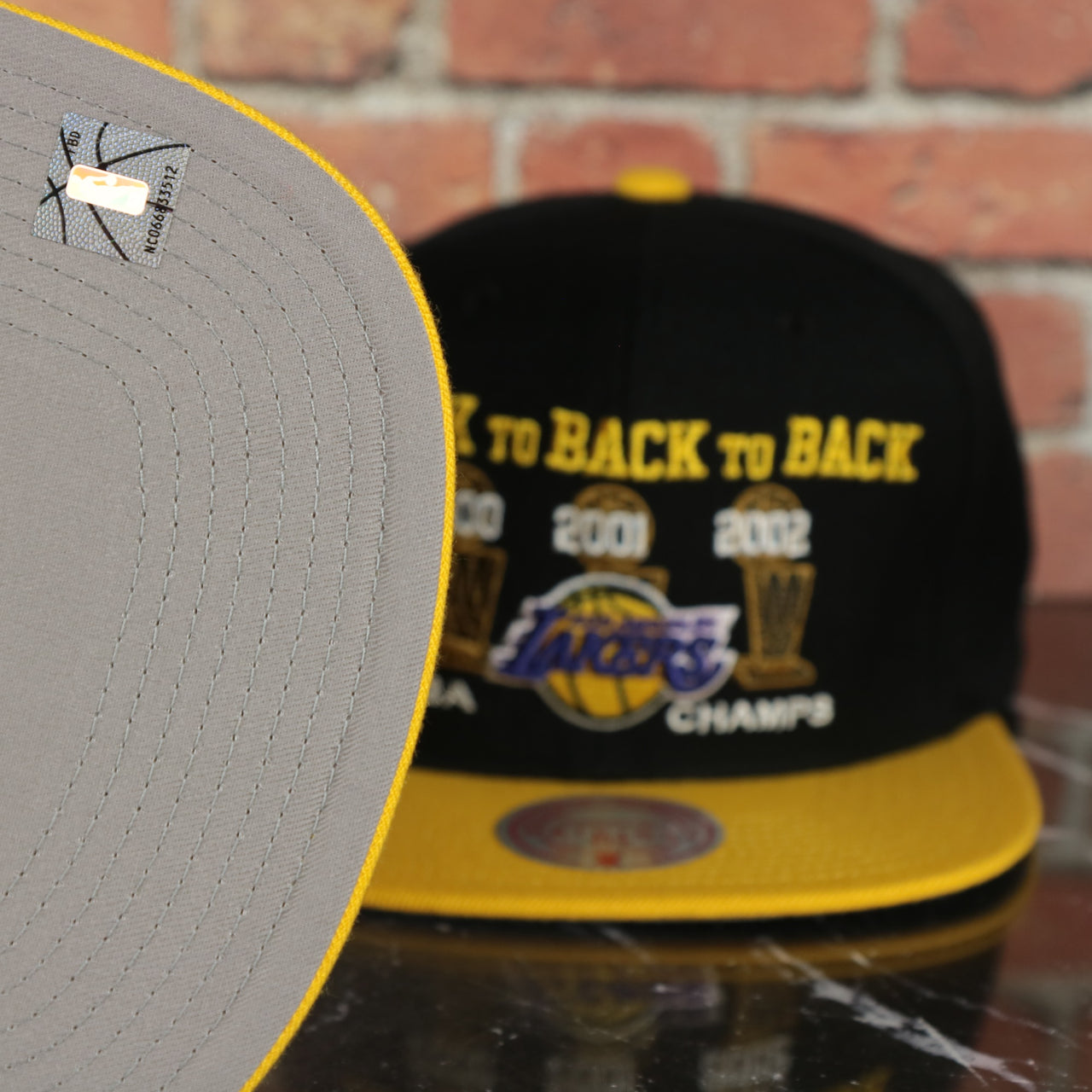 grey under visor on the Los Angeles Lakers Vintage Retro NBA Champions 00-02 Back to Back to Back Mitchell and Ness Snapback Hat | Black