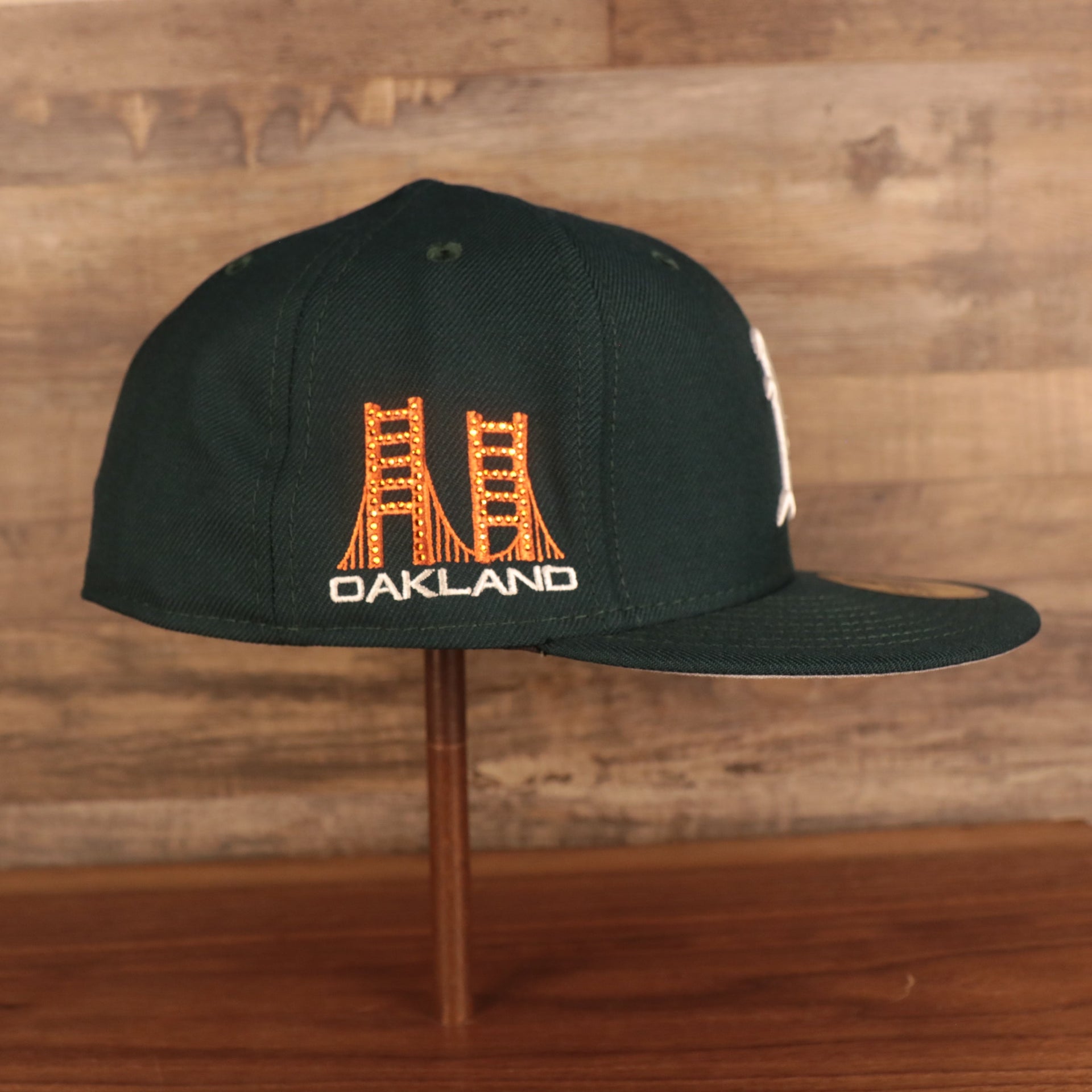 Wearer's right of the Oakland Athletics Iced Out Side Patch Flower Oakland Bridge Gray Bottom 59Fifty Fitted Cap