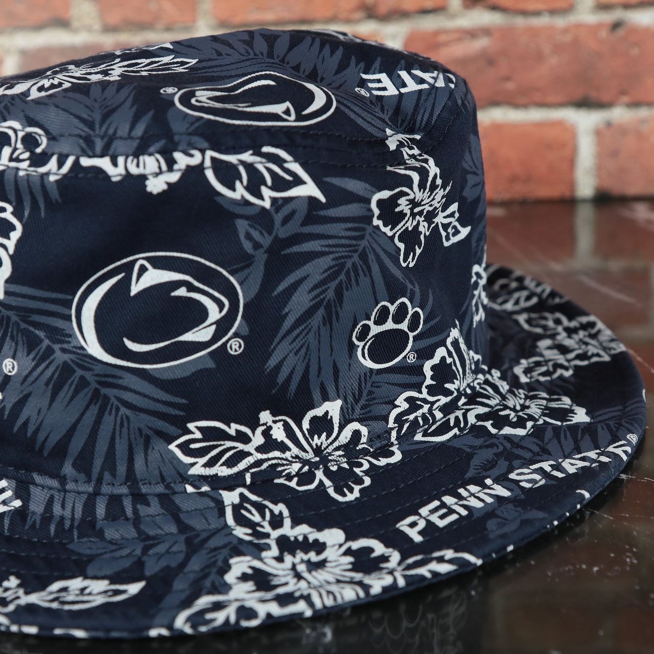 lions logo on the Penn State Nittany Lions Floral Aloha Print Navy Bucket Hat | Reyn Spooner