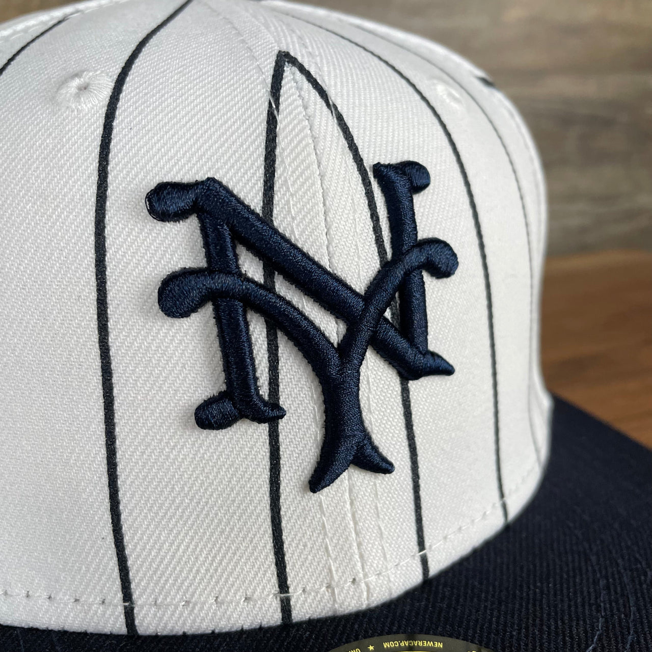 A close up of the giants logo on the New York Giants Cooperstown 5950 Day Side Patch Green Bottom 59Fifty Fitted Cap