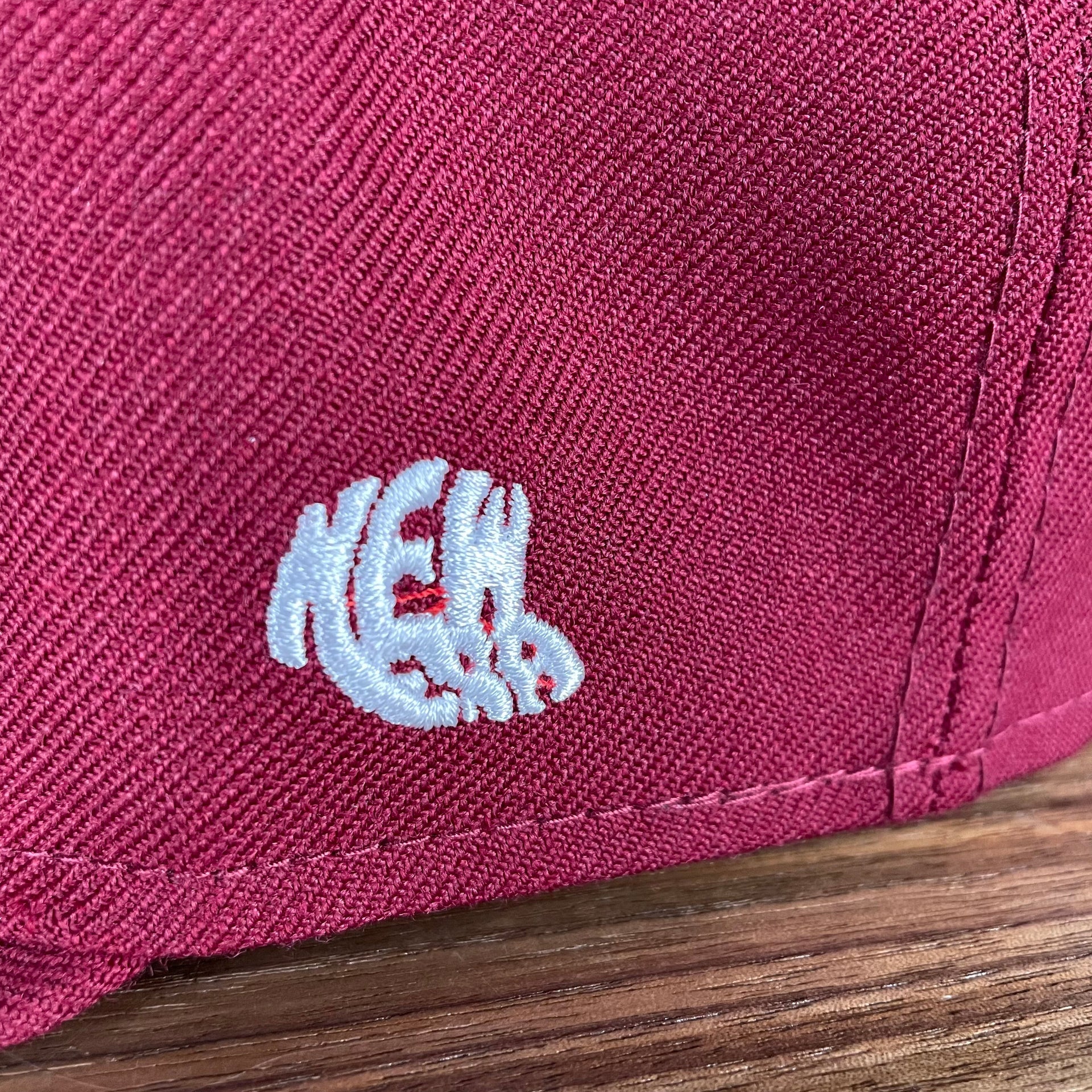 A close up of the 1960s New Era logo on the Philadelphia Phillies Cooperstown 5950 Day Side Patch Green Bottom 59Fifty Fitted Cap