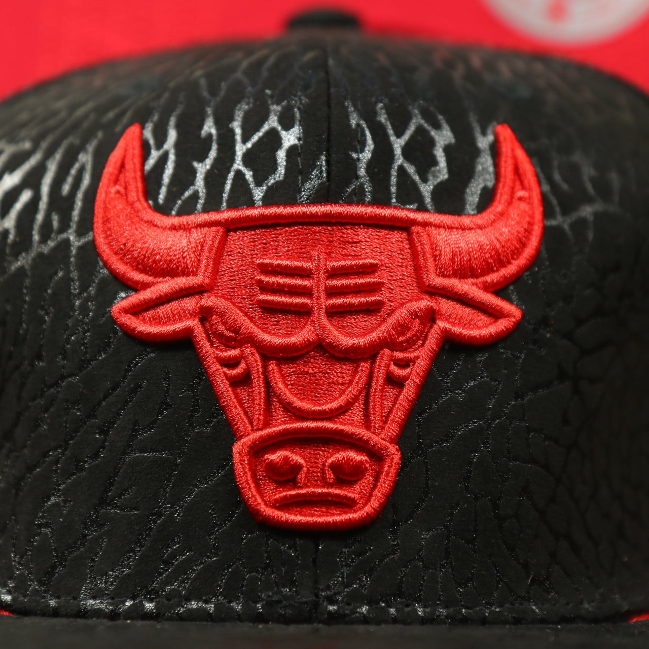 Close up of the all red Bulls logo on the Chicago Bulls “NBA Day 5” Satin Bred 5s Matching Snapback Hat | Snapback to match Satin Bred 5s