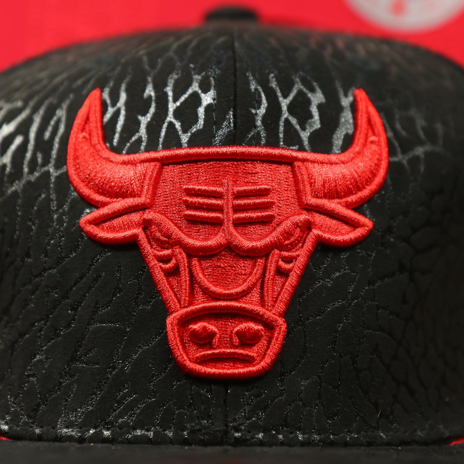 Close up of the all red Bulls logo on the Chicago Bulls “NBA Day 5” Satin Bred 5s Matching Snapback Hat | Snapback to match Satin Bred 5s