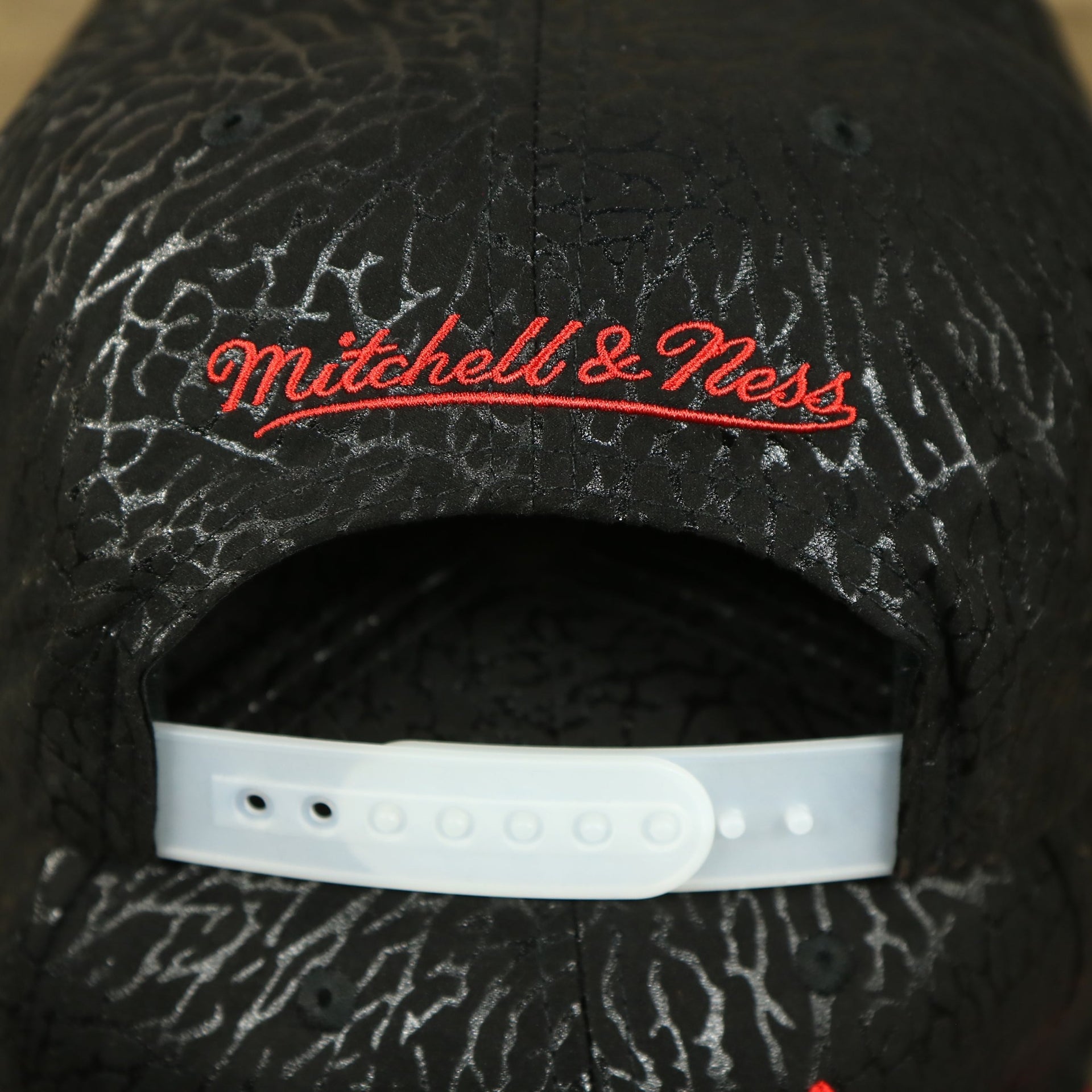 Close up of the Mitchell and Ness script on the back of the Chicago Bulls “NBA Day 5” Satin Bred 5s Matching Snapback Hat | Snapback to match Satin Bred 5s