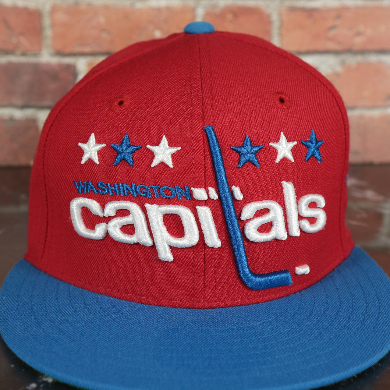 capitals logo on the Washington Capitals 2-Tone Fitted Cap Green Bottom | Blue/Red Cap