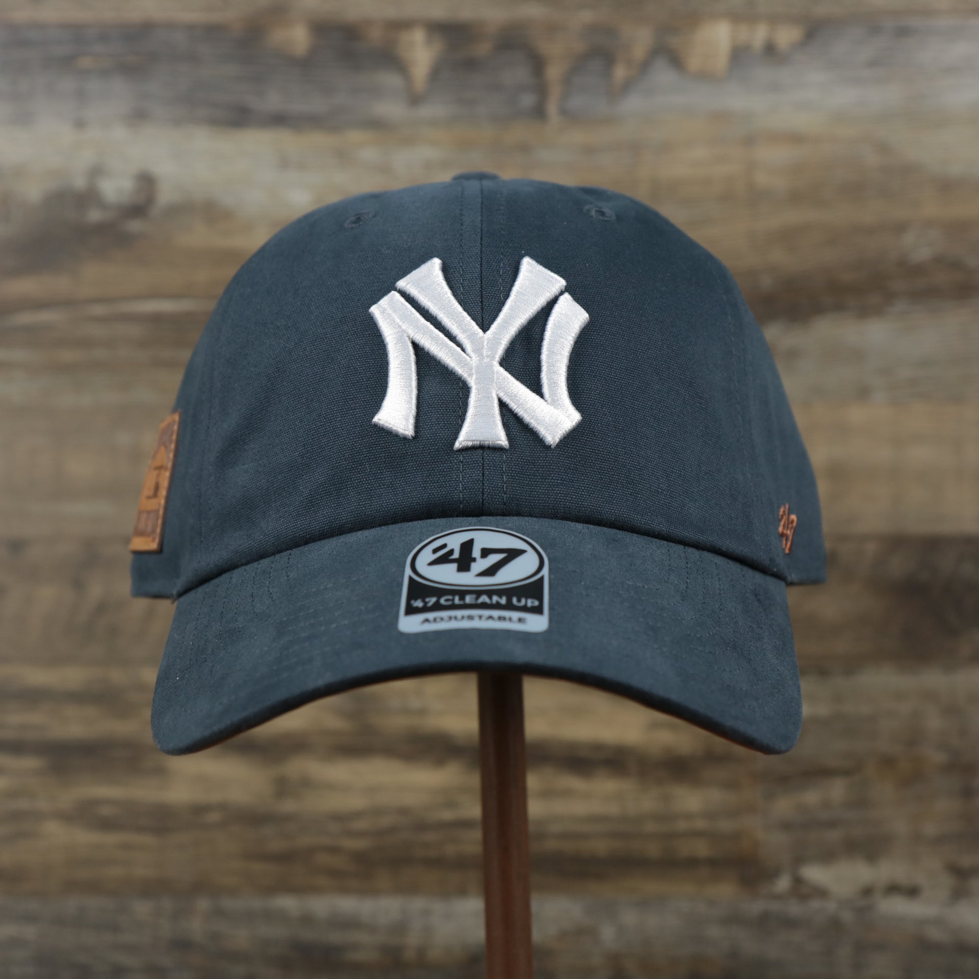 The front of the Cooperstown New York Yankees Cooperstown Collection Side Patch Leather Brown Undervisor Dad Hat | Vintage Navy Dad Hat