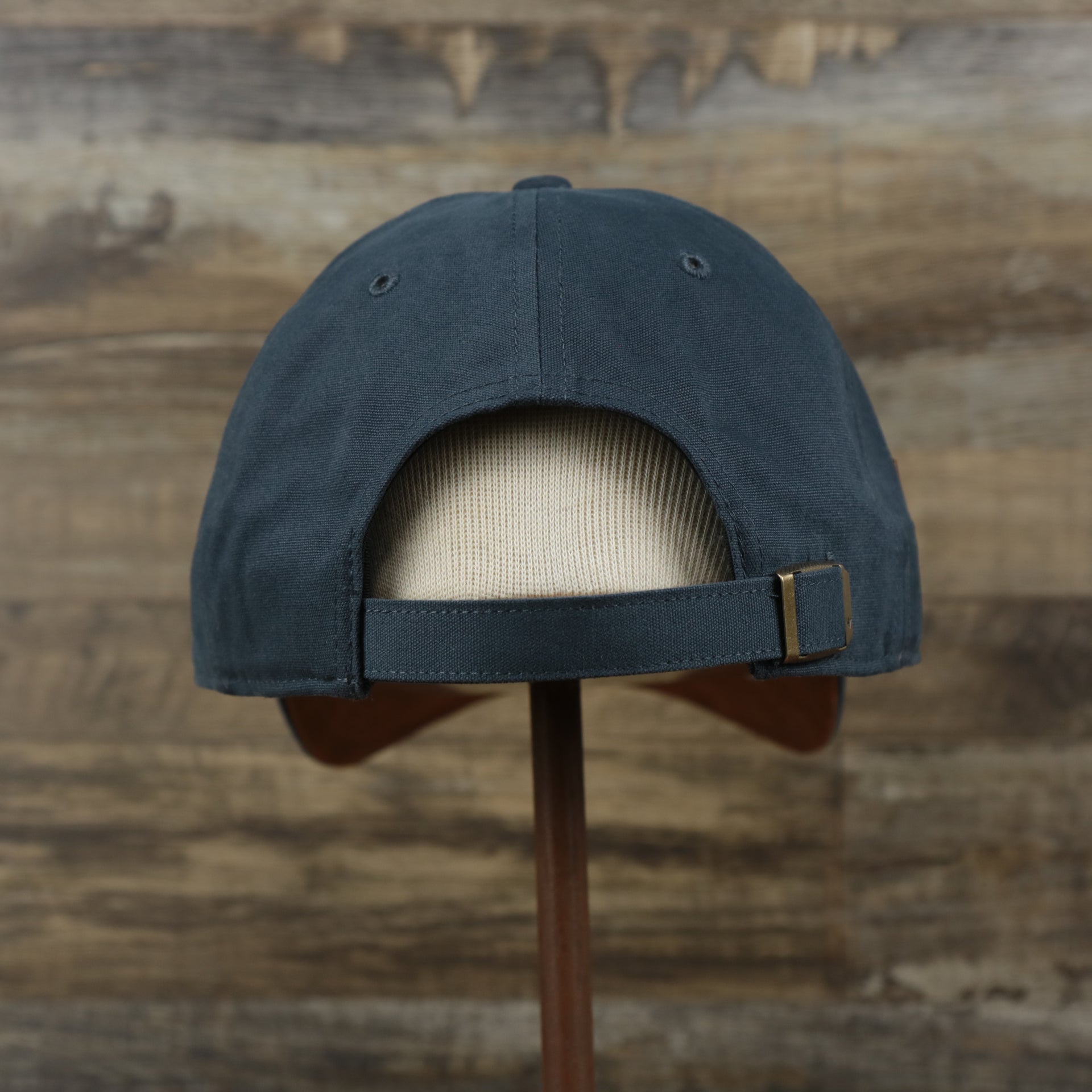 The backside of the Cooperstown New York Yankees Cooperstown Collection Side Patch Leather Brown Undervisor Dad Hat | Vintage Navy Dad Hat